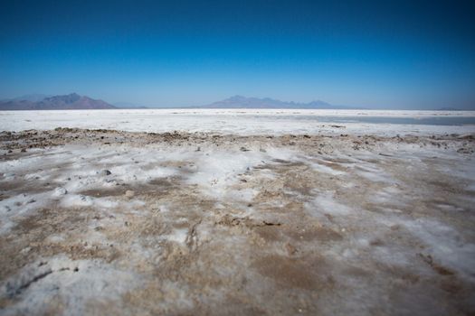World famous Bonneville Salt Flats outside Salt Lake City Utah with mountains and blue skies. Detail of the salt on the ground
