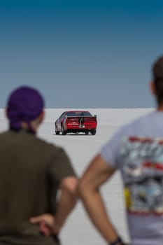 BONNEVILLE SALT FLATS, UTAH, SEPTEMBER 8: Two unidentified men looking a hot rod riding in the background during the World of Speed 2012 close to Salt Lake City.