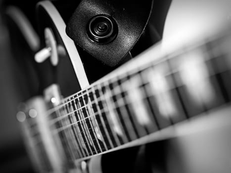 Macro abstract black and white photo of the neck and frets of an electric guitar.
