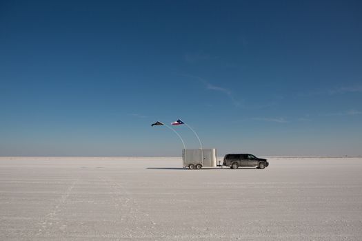 SUV driving with trailer at Bonneville Salt Lake Flats