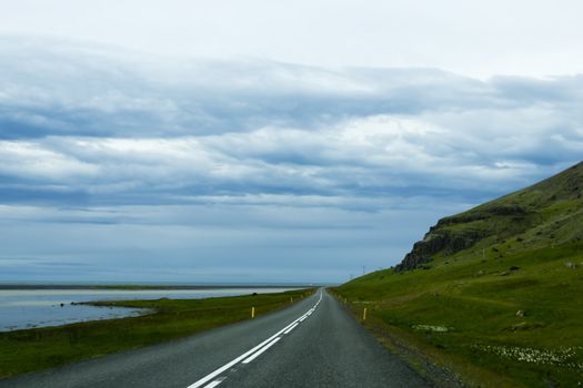 Road against mountain background, Iceland, cloudy summer weather