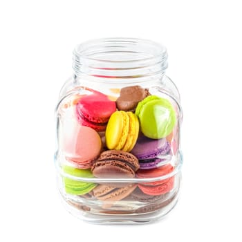 traditional french colorful macarons in a glass jar on white background