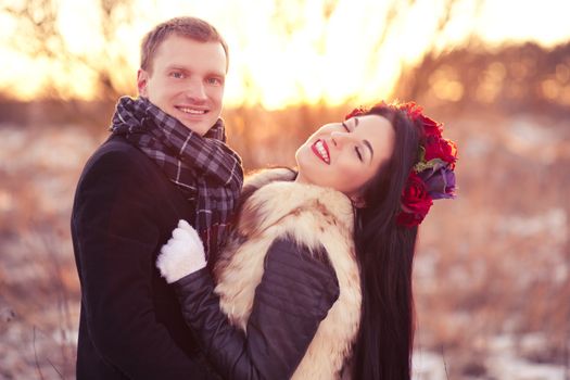 Cheerfull young lovers are smiling and hugging in sunlight