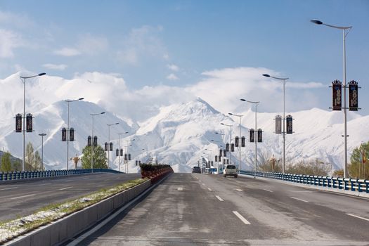 Leaving Lhasa on an empty Friendship Highway with a stunning view of the Himalayan mountain chain in the background. Tibet, China 2013.