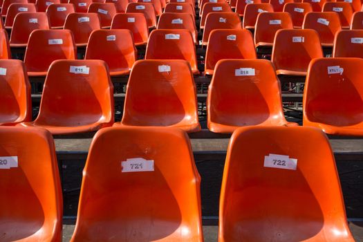 Lots of orange seats at an outdoor venue.