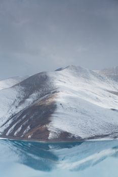 Detail of the Yamdrok lake on the Friendship road in Tibet with snow on the mountains