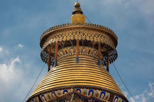 Golden Rooftop of the Pelkhor Chode Monastery in Tibet with a cloudy sky in the background
