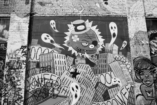 Graffiti on the wall of a building Near Mission street in San Francisco. Black and white vision of a messed up city.