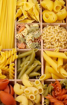 Various Raw Dry Pasta closeup in Wooden Sections