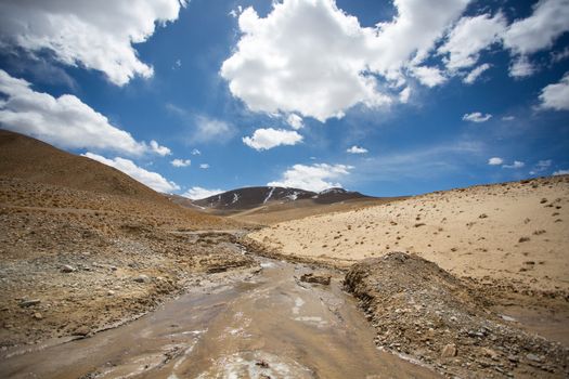 Tibetan landscape on the Friendshiip Highway in Tibet with blue sky and a massive river.