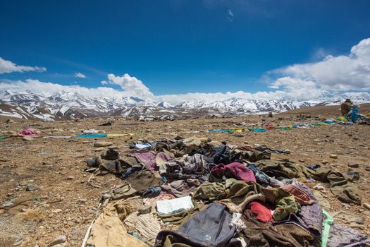 Waste and old clothes with the Himalayas mountain range in the background. Friendship Highway bewteen Nepal and Tibet. China 2013.