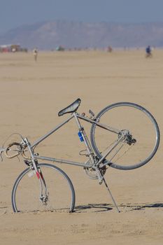 Gray bicycle with nobody, stuck in the sand of the Black Rock desert, Nevada