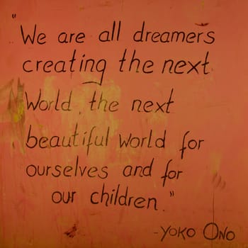 Orange Peace message written on a wall, a famous say from Yoko Ono telling that we have to create the beautiful next world