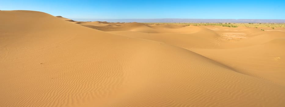 Sahara desert close to Merzouga in Morocco with blue sky and clouds.