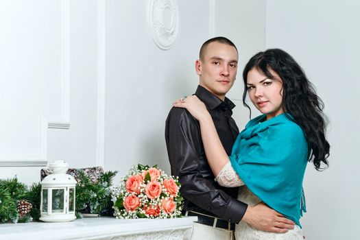 Attractive young couple hugging each other in room