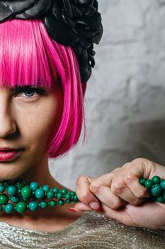 Attractive young girl with rim on head holding beads shot closeup