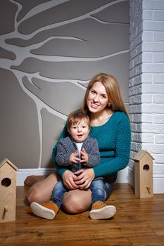 Attractive young blond mother holding her baby in her arms