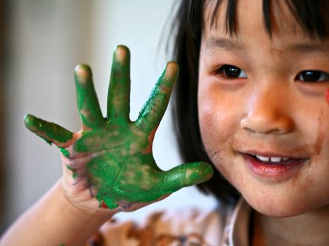 close up of  child face playing with finger painting