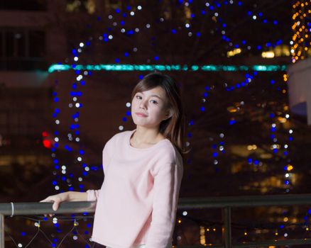 Pretty Malaysian female with blue lights behind her