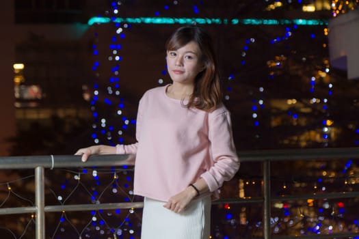 Pretty Malaysian female with blue lights behind her