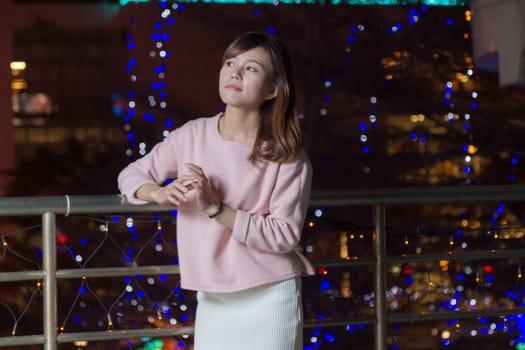 Pretty Malaysian female with blue lights behind her