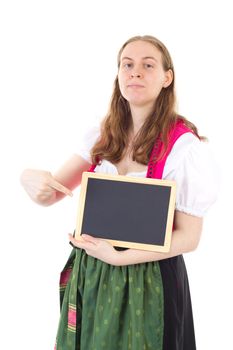 Young woman in dirndl pointing at blank blackboard