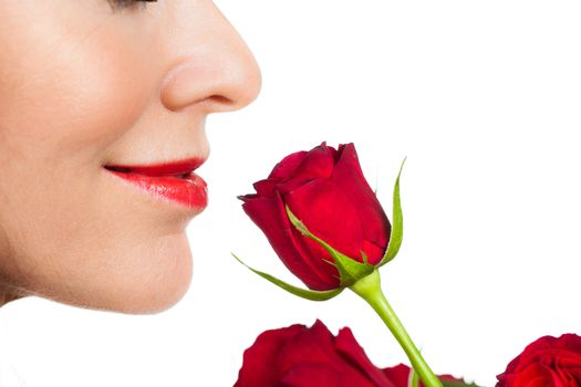 Close-up profile shot of a beautiful woman smelling a rose. Isolated on white.