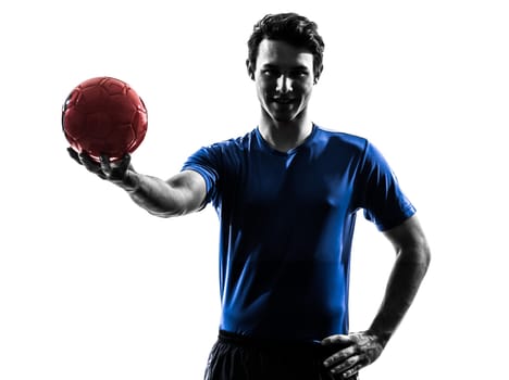 one caucasian young man exercising handball player in silhouette studio on white background