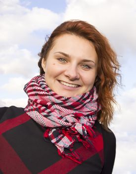 Beautiful girl with red hair against blue sky background