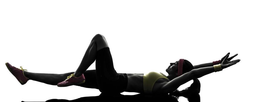 one woman exercising fitness stretching lying on back in silhouette on white background
