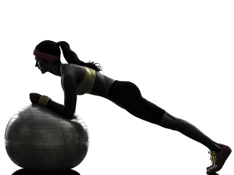 one woman exercising plank position on fitness ball in silhouette on white background