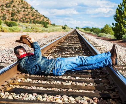 famous cow-boy boots and feets across train tracks 