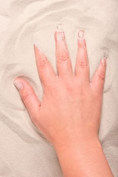 female hand touches the fine sand