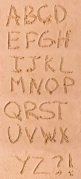 English alphabet written in sand on the beach