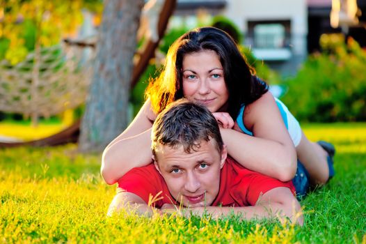 couple in love lies on a green lawn