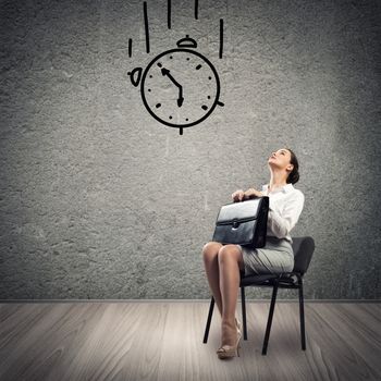 image of a young business woman looking at the sketched clock