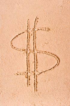 Dollar symbol drawn on wet sand on the beach