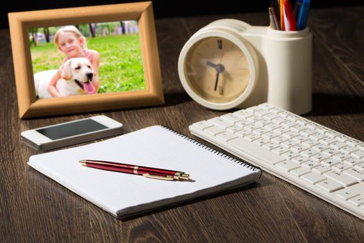 photo frame, mobile phone and notebook with a ballpoint pen. Workplace of the businessman.