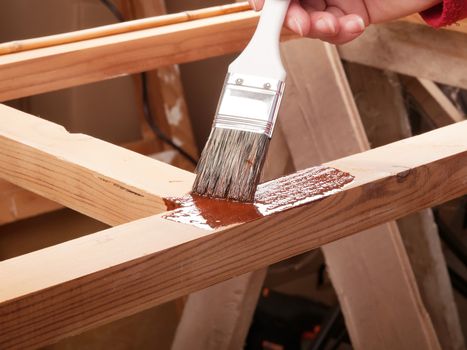 applying protective primer on wooden rack