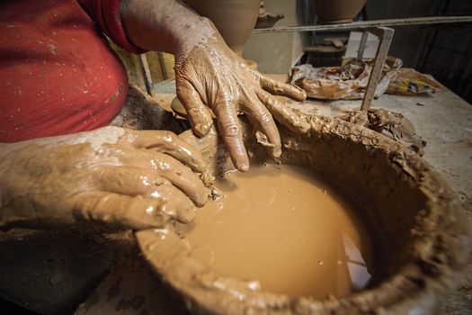 Detail of a potter's hands in a bucket of water