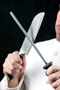 Close-up of a chef sharpening his knife, side.