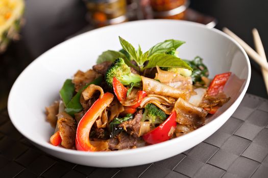 Pad kee mao drunken noodle thai disk with beef and mixed vegetables.