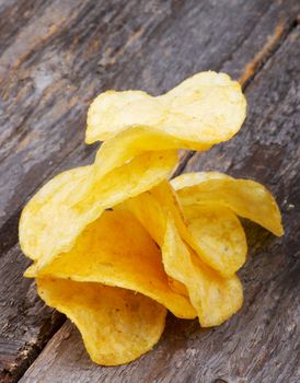 Pile of Crispy Cheese Potato Chips closeup on Rustic Wooden background