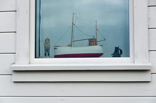 old fisherman with his boat in a window