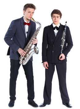 Young mans in a suit playing on saxophone and clarinet. Isolated on background