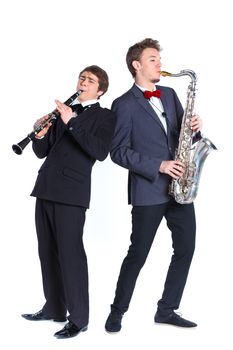 Young mans in a suit playing on saxophone and clarinet. Isolated on background