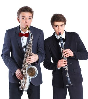 Portrait of a young mans in a suit playing on saxophone and clarinet. Isolated on background