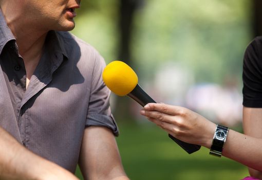 A journalist is making a interview with a microphone