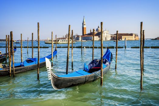 Gondolas moored by Saint Mark square with San Giorgio di Maggiore church in the background - Venice, Venezia, Italy, Europe 