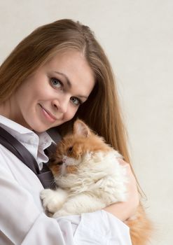 The young nice girl holds a red Persian cat on hands